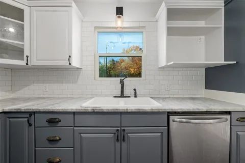 a kitchen with granite countertop a sink and a stove