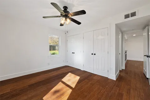 a view of a big room with wooden floor closet and windows