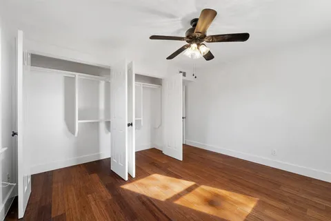 a view of empty room with wooden floor