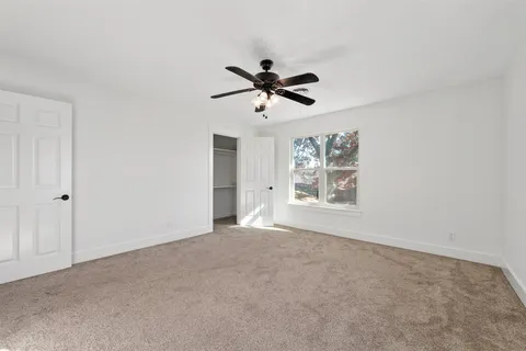 a view of a livingroom with a ceiling fan and window
