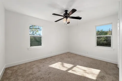 a view of a big room with wooden floor and windows