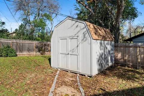 a view of backyard of house with wooden fence