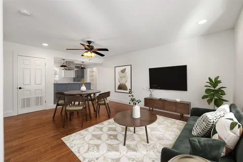 a living room with furniture a rug and a flat screen tv