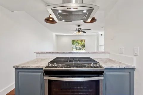 a stove top oven sitting inside of a kitchen