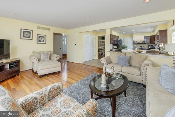 a dining hall with stainless steel appliances granite countertop a sink a stove a table and chairs