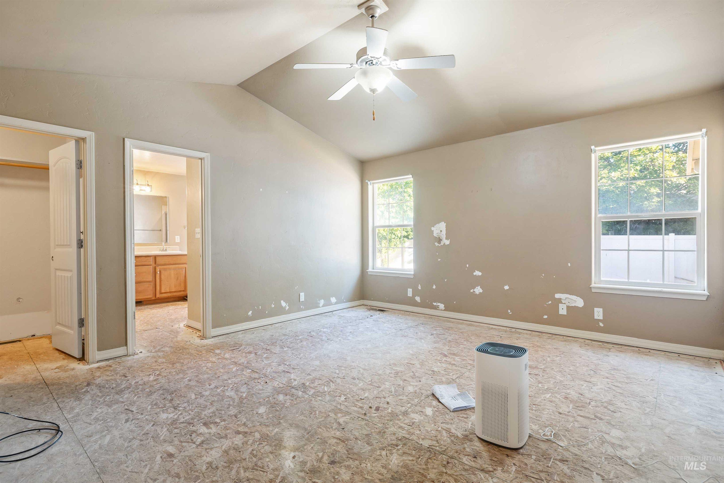 2509 Cedar Ridge Road Twin Falls, ID 83301 - Photo 8 of 36 Vaulted ceiling with ceiling fan, dual windows, and adjacent bathroom with wood-finish vanity
