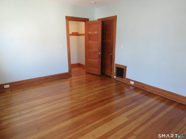 an empty room with wooden floor and closet