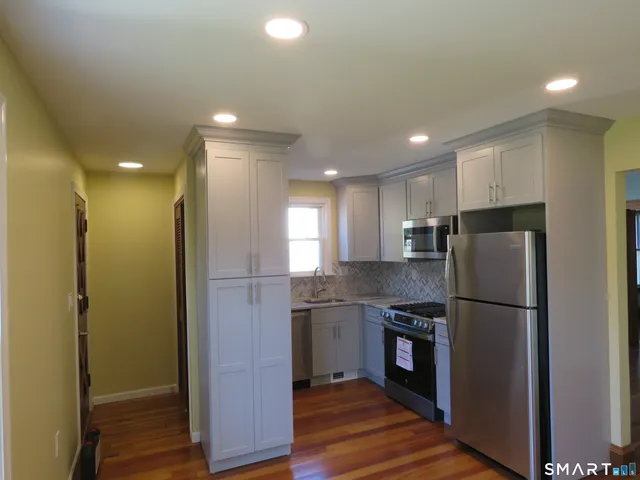 a kitchen with stainless steel appliances granite countertop a refrigerator and a stove top oven