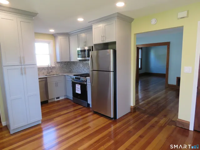 a kitchen with stainless steel appliances granite countertop a refrigerator and a stove