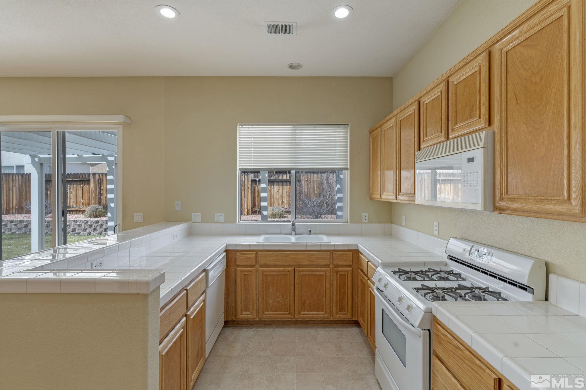 10503 Meeks Bay Court Reno, NV 89521 - Photo 11 of 28 a kitchen with granite countertop a sink stove and cabinets