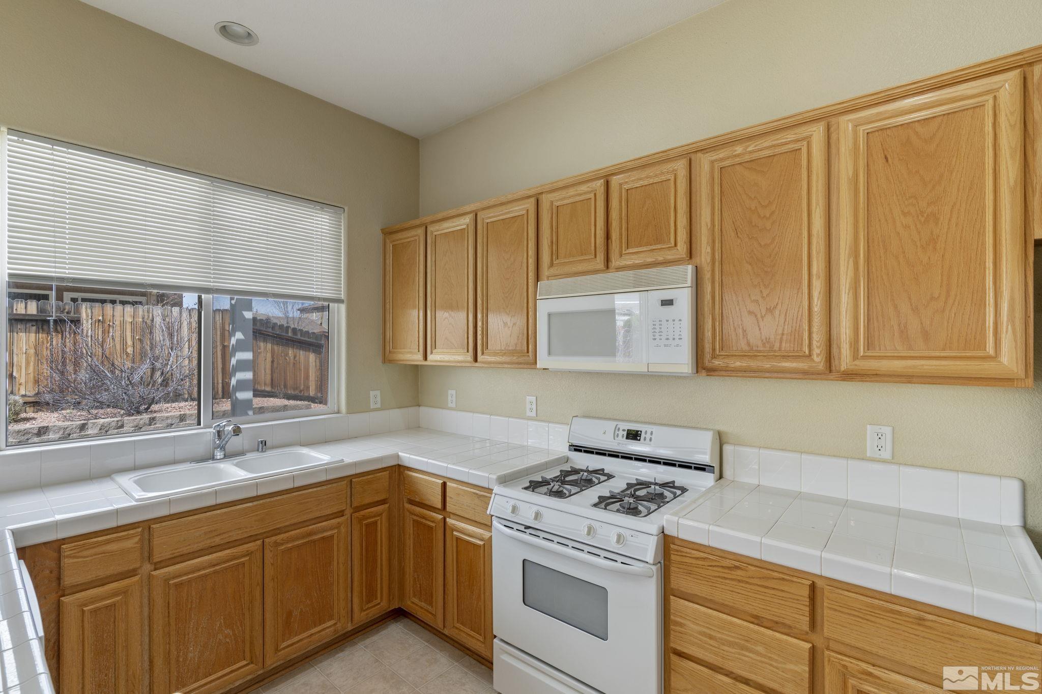 10503 Meeks Bay Court Reno, NV 89521 - Photo 12 of 28 a kitchen with granite countertop cabinets stainless steel appliances and a sink