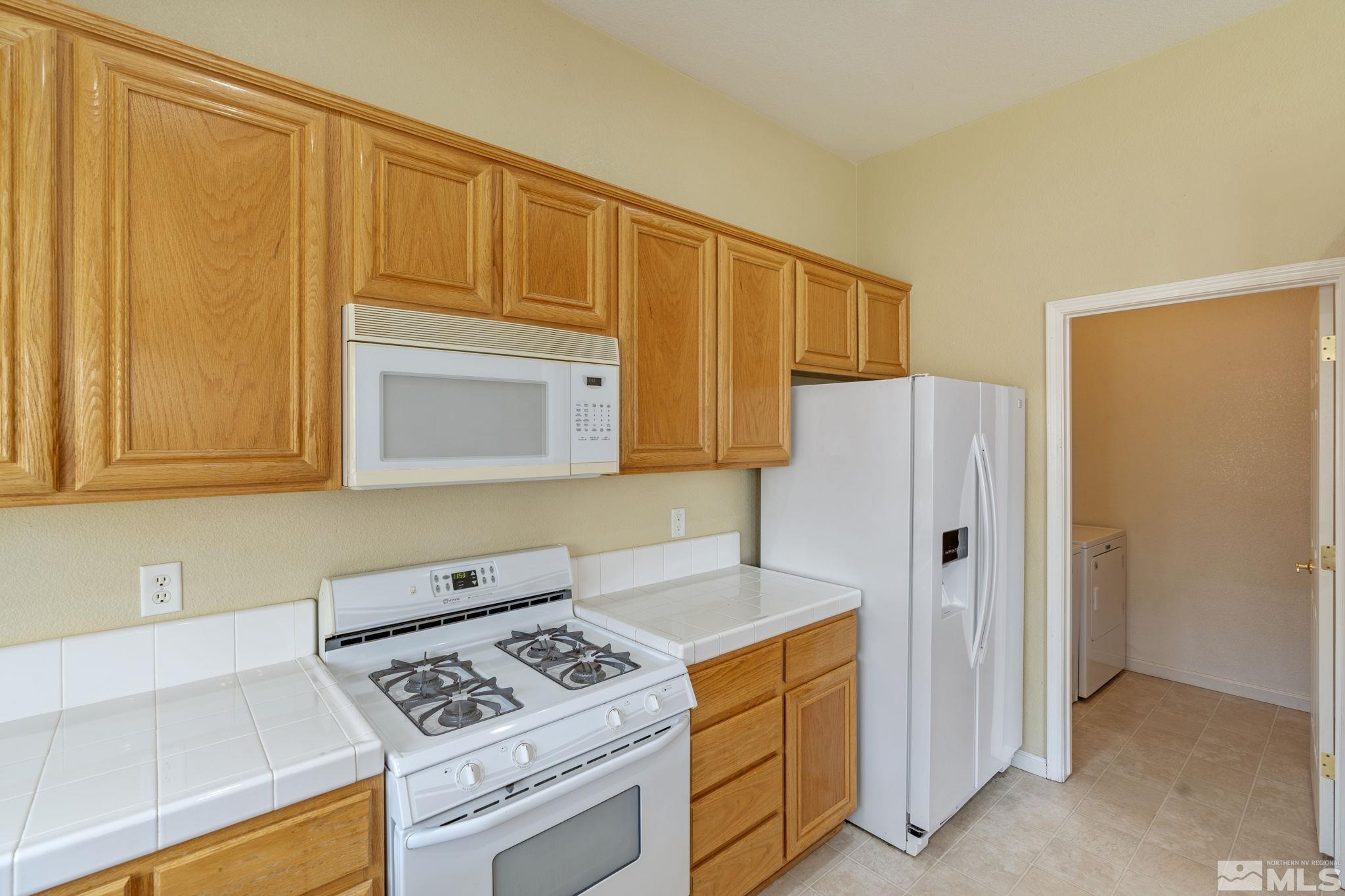 10503 Meeks Bay Court Reno, NV 89521 - Photo 13 of 28 a kitchen with stainless steel appliances granite countertop white cabinets and a refrigerator