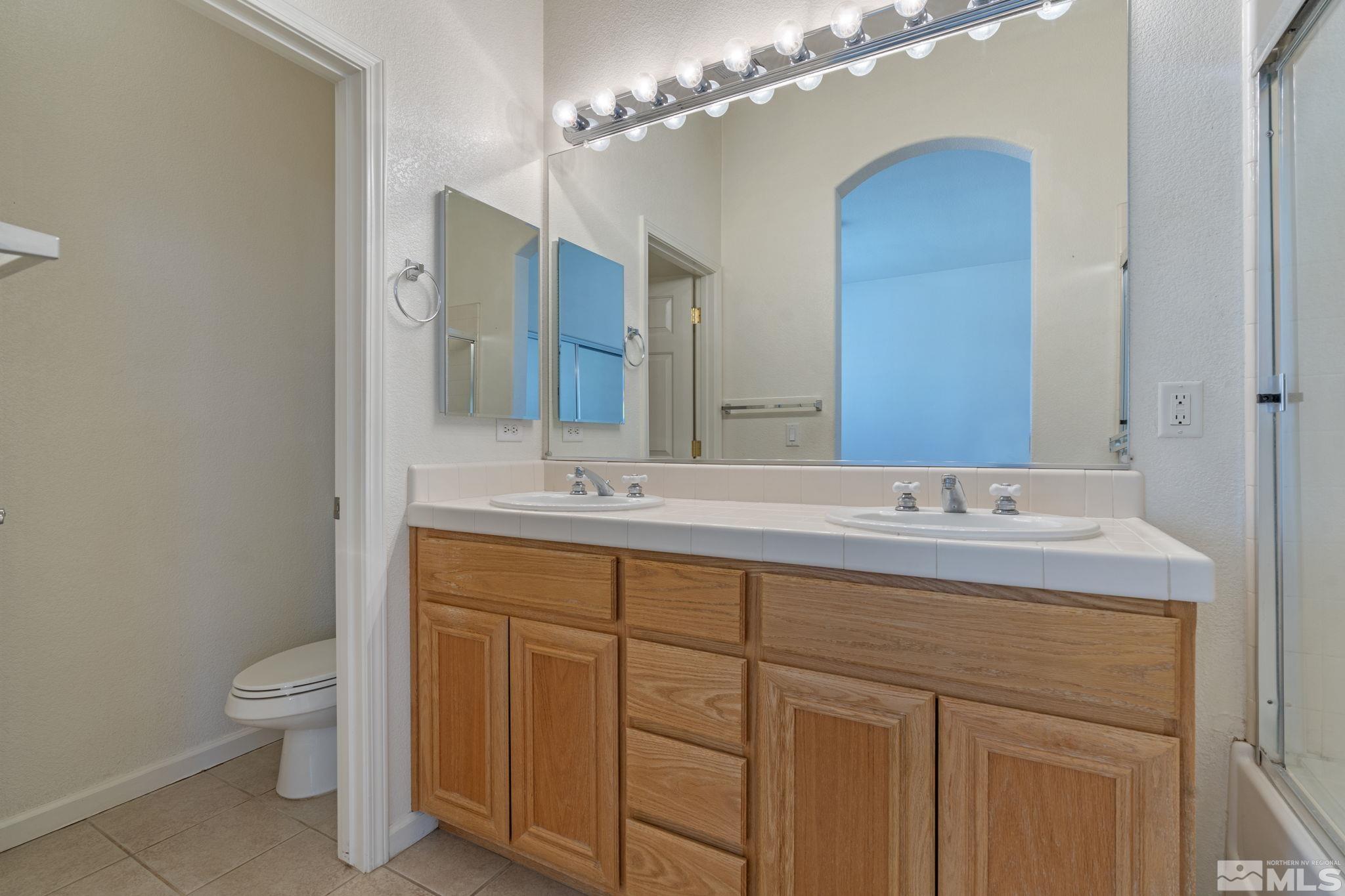 10503 Meeks Bay Court Reno, NV 89521 - Photo 18 of 28 a bathroom with a toilet sink and mirror