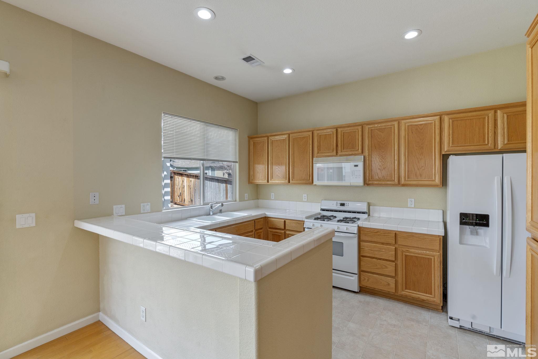 10503 Meeks Bay Court Reno, NV 89521 - Photo 9 of 28 a kitchen with a stove a sink a refrigerator and cabinets