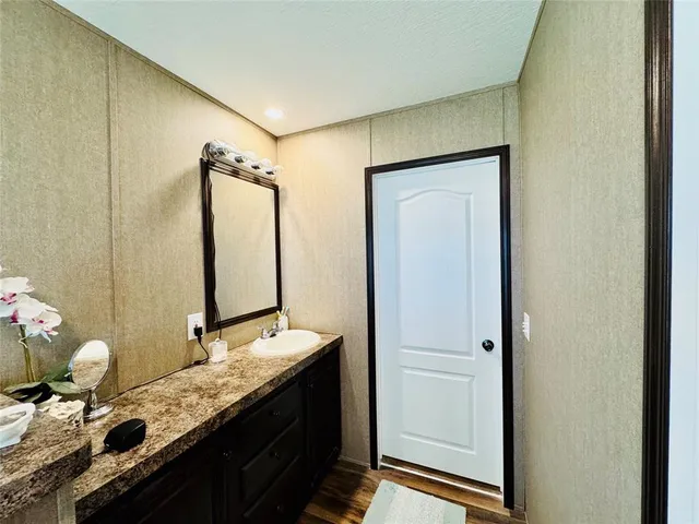 a bathroom with a granite countertop sink and a mirror