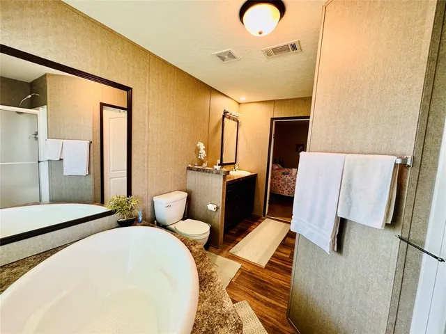 a bedroom with a bed and dresser with mirror