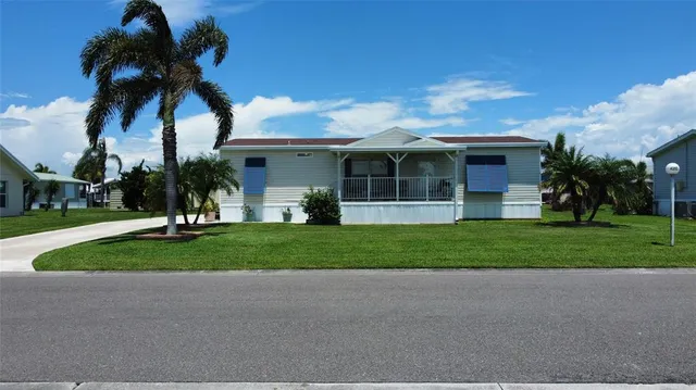 a view of a house with a yard and palm trees