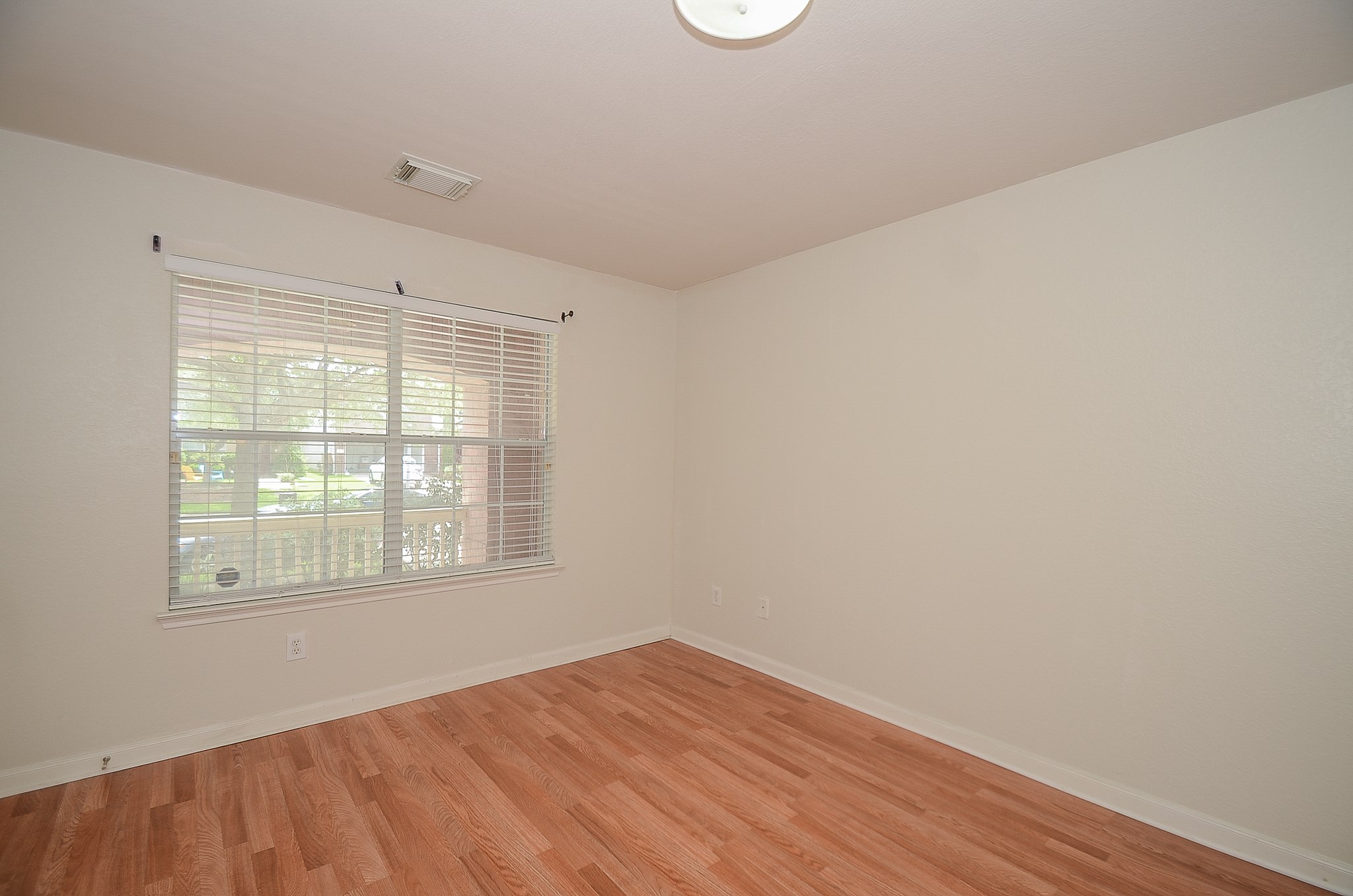 11711 Wainscot Court Houston, TX 77038 - Photo 20 of 32 an empty room with wooden floor and windows