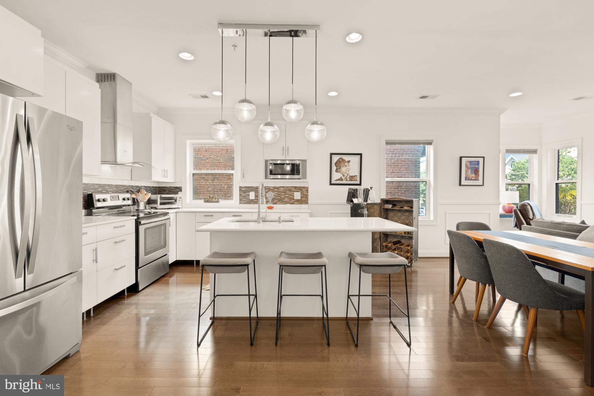 233 S Street Northeast, Unit 4 Washington, DC 20002 - Photo 12 of 37 a kitchen with a dining table chairs wooden floor cabinets and appliances