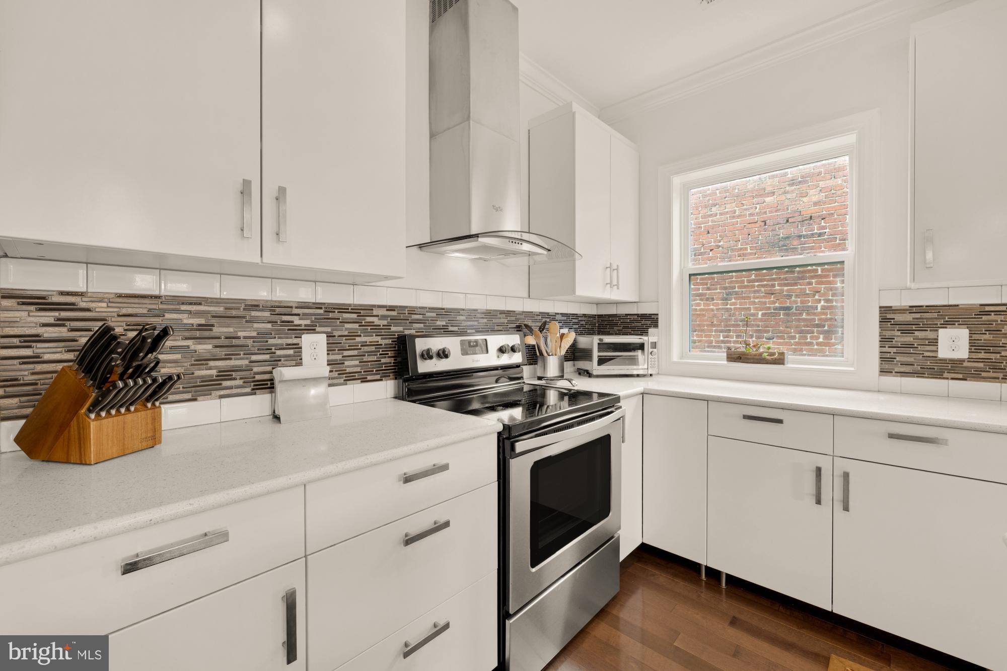 233 S Street Northeast, Unit 4 Washington, DC 20002 - Photo 16 of 37 a kitchen with white cabinets and white appliances