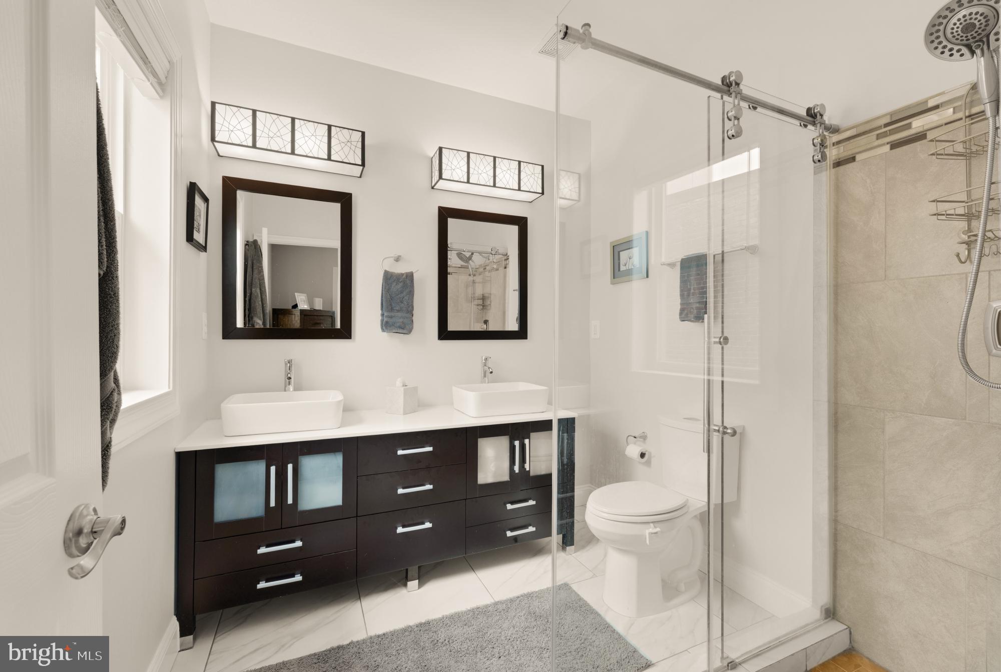 233 S Street Northeast, Unit 4 Washington, DC 20002 - Photo 28 of 37 a bathroom with a double vanity sink toilet mirror and shower
