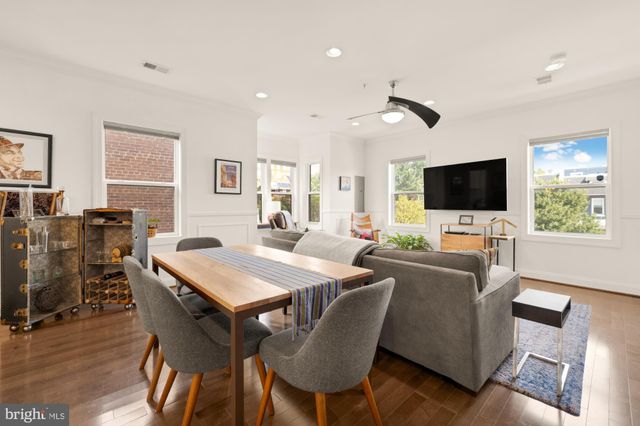 a living room with furniture a flat screen tv and a dining table