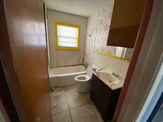 a bathroom with a sink a toilet and shower curtain