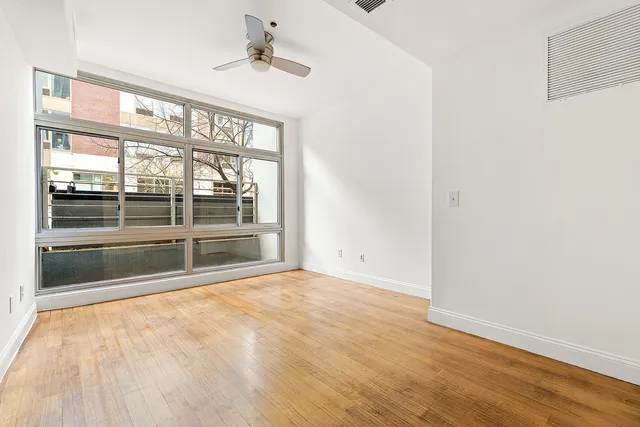 an empty room with windows and mirror