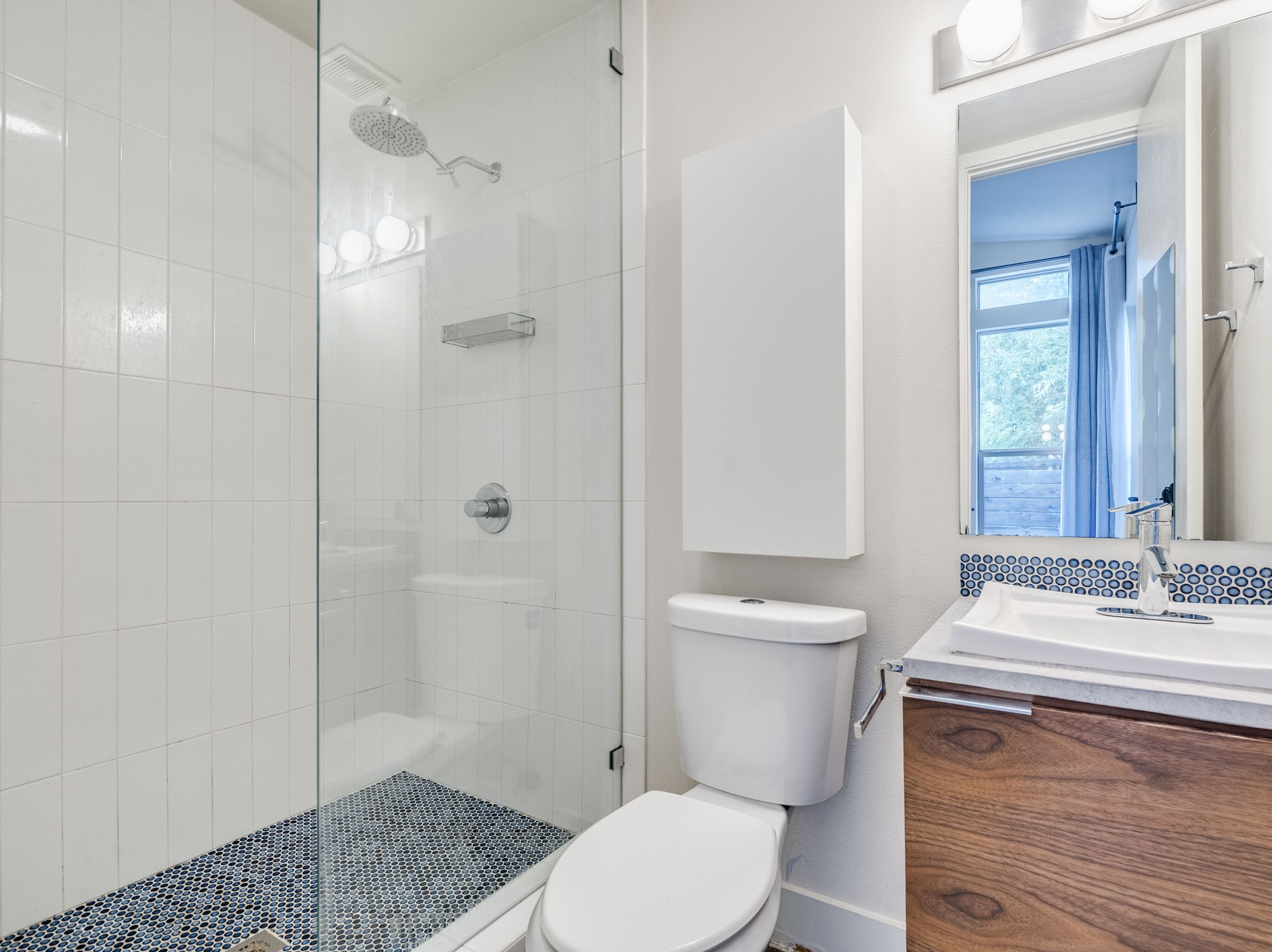 1404 Singleton Avenue, Unit B Austin, TX 78702 - Photo 14 of 21 A sleek, contemporary bathroom with a glass-enclosed shower and mosaic tile details.