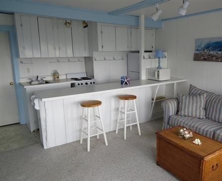 73 Main Street, Unit 6 Chatham, MA 02633 - Photo 3 of 8 a kitchen with stainless steel appliances granite countertop a white table and chairs