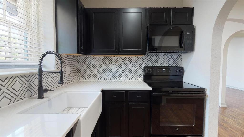 5506 Miller Avenue, Unit 202 Dallas, TX 75206 - Photo 2 of 17 a kitchen with a sink and a stove top oven with wooden floor