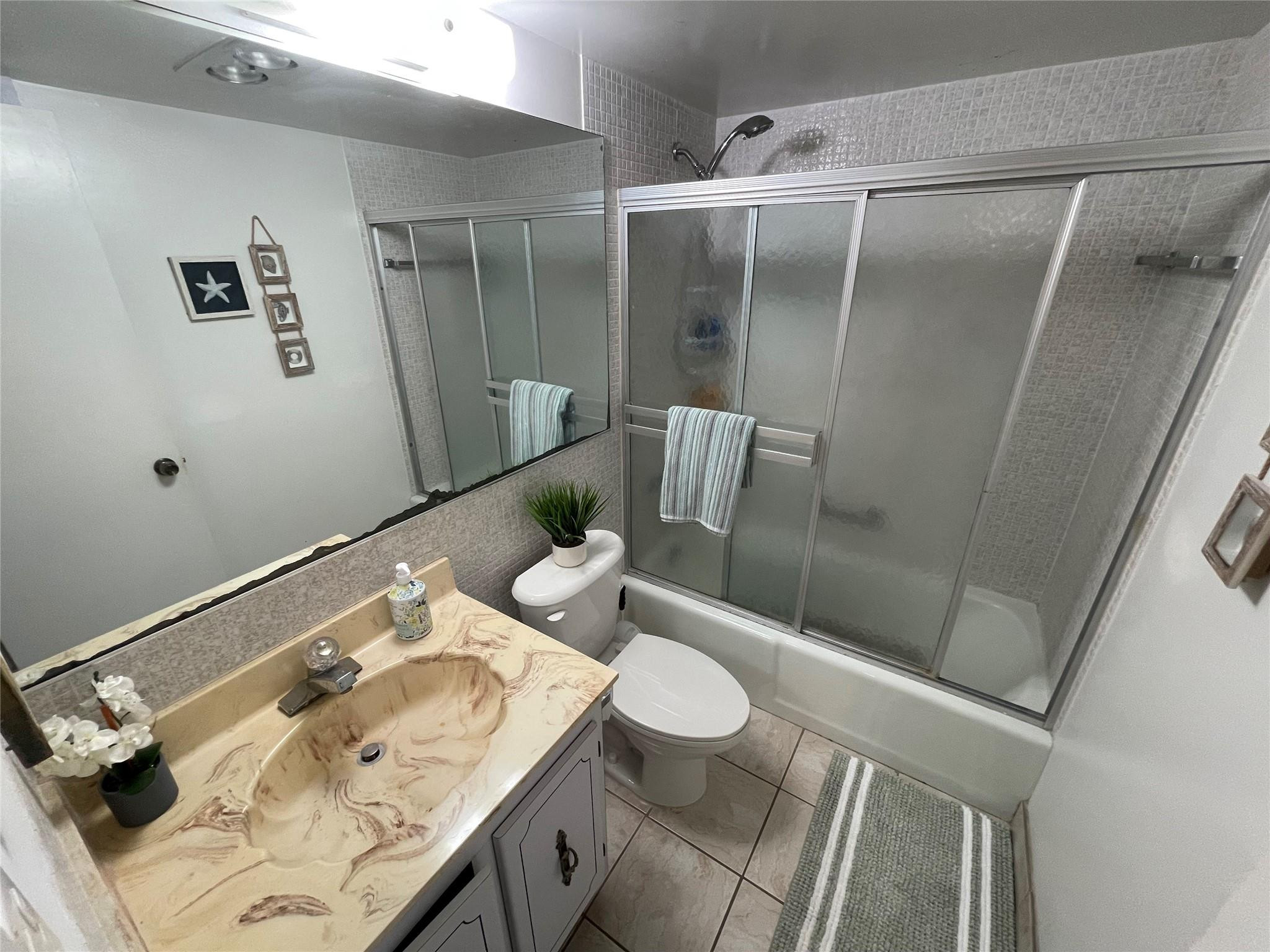 259 South Cypress Road, Unit 536 Pompano Beach, FL 33060 - Photo 13 of 39 a bathroom with a sink and mirror with bathtub