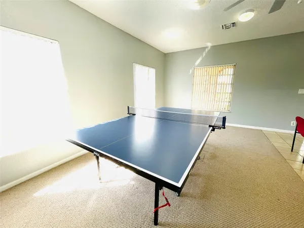 a living room with kitchen pool table and chairs