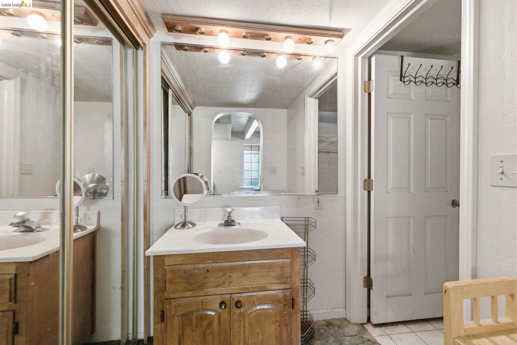 23608 Porcina Way Columbia, CA 95310 - Photo 15 of 51 a bathroom with a sink a mirror a vanity and shower