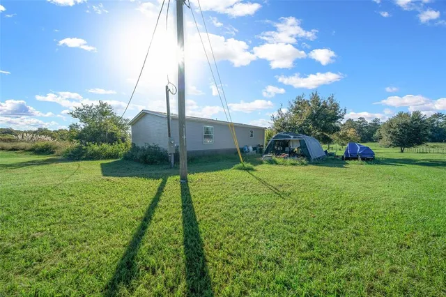 a view of a chair and table in backyard of the house