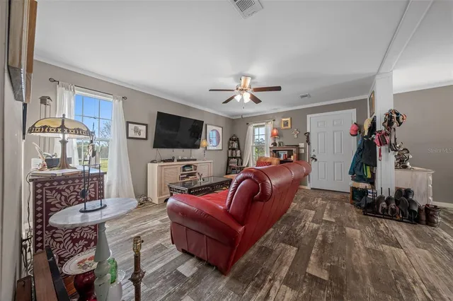a living room with furniture kitchen view and a window