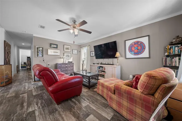 a kitchen with stainless steel appliances kitchen island granite countertop a refrigerator a oven a sink and white cabinets with wooden floor