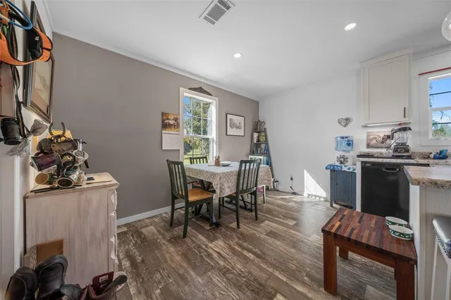 a kitchen that has a lot of cabinets a sink and a wooden floor