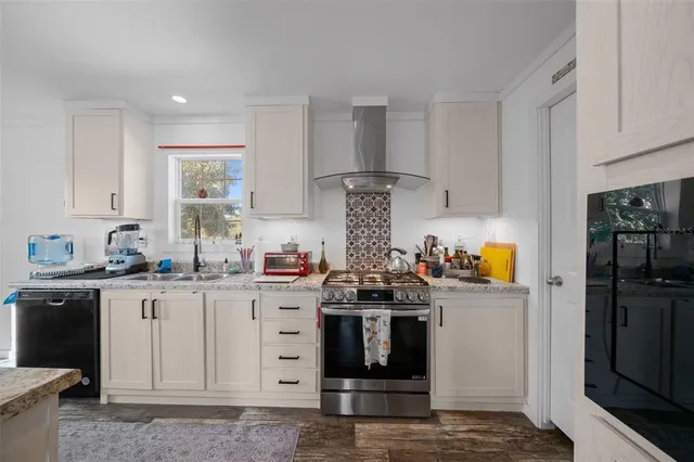 a kitchen with stainless steel appliances granite countertop sink stove refrigerator and cabinets