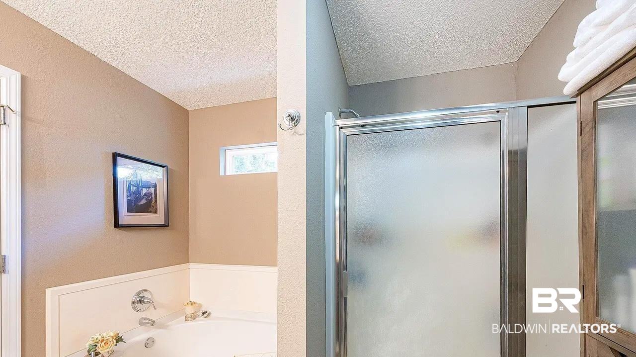 12230 Bromley Road Stapleton, AL 36578 - Photo 21 of 34 Bathroom featuring a bath, a textured ceiling, and a stall shower