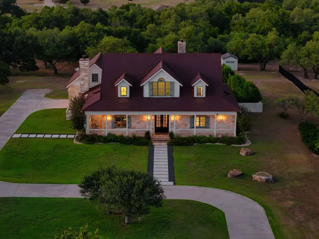 a aerial view of a house next to a big yard and large trees