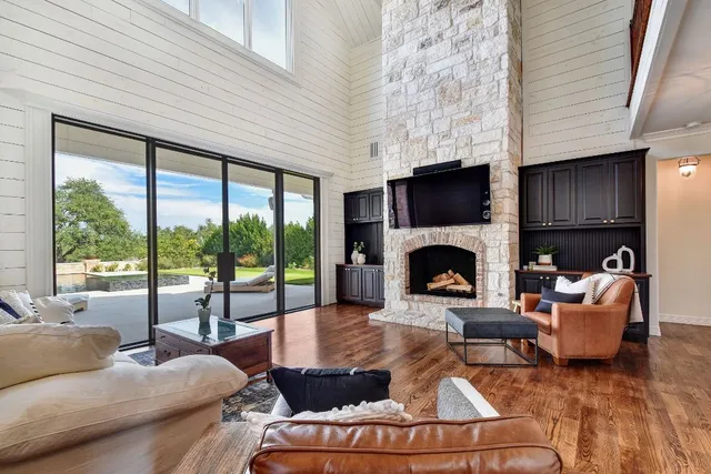 a living room with furniture fireplace and a large window