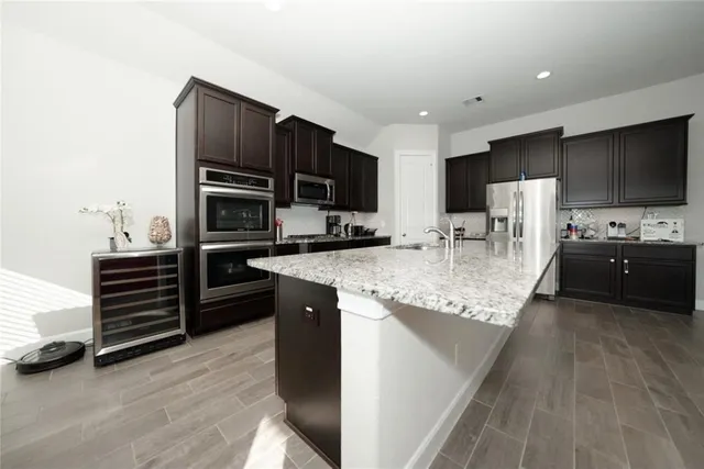 a kitchen with stainless steel appliances kitchen island granite countertop a stove and a refrigerator