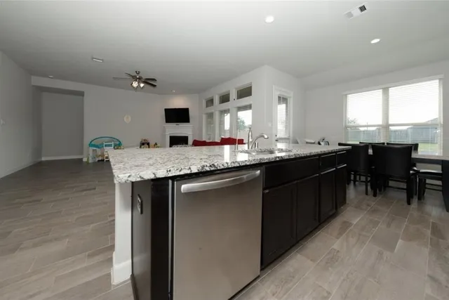 a kitchen with kitchen island granite countertop a sink cabinets and window