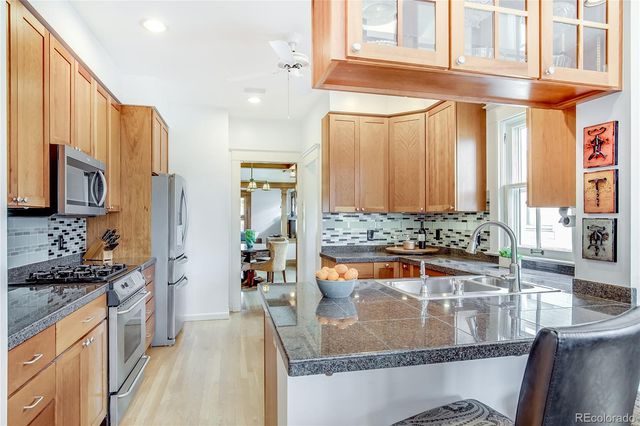 a kitchen with stainless steel appliances granite countertop a stove a sink and a refrigerator