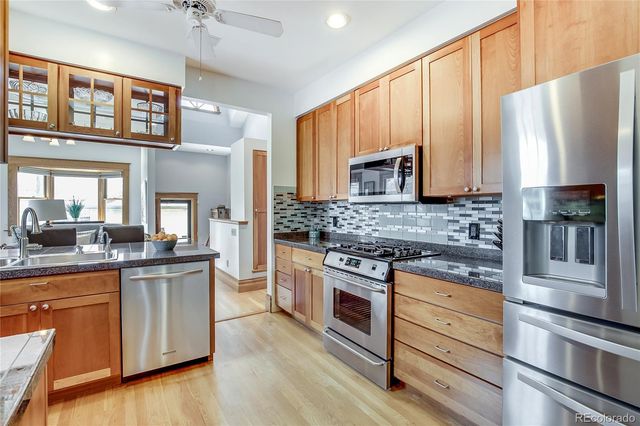 a kitchen with granite countertop a refrigerator stove and microwave