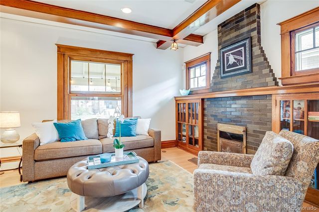 a living room with furniture a fireplace and a large window
