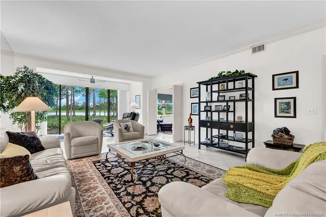a living room with furniture ceiling fan and a window