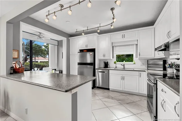 a kitchen with stainless steel appliances granite countertop a sink a stove and a refrigerator