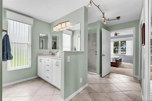 a spacious bathroom with a double vanity sink a mirror and a shower